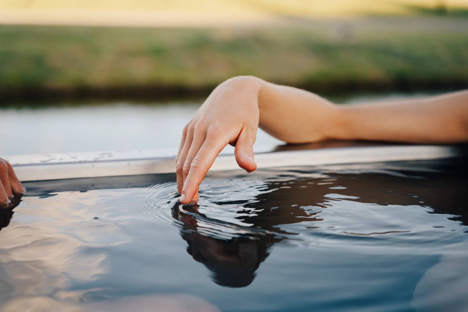 Hand touching water in a Stoked tub