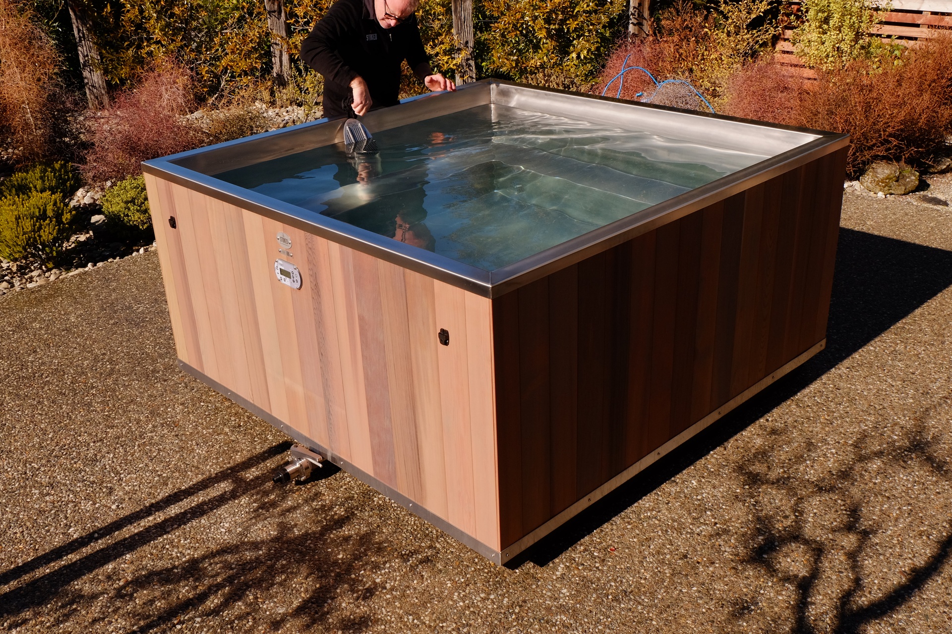 Stoked craftsman working on a square stainless steel tub